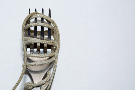Shoestrings or electric cable to eat with a fork on white background. Bad and disgusting meal...