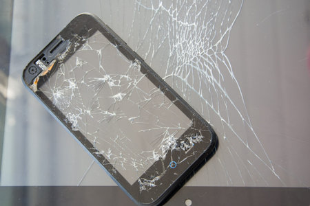 A smartphone with a broken screen and a tablet computer with a broken touchscreen. Broken glass...