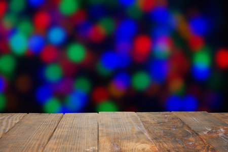 Empty table and blurred colorful trendy festive background of blurry lights. Christmas lights on...