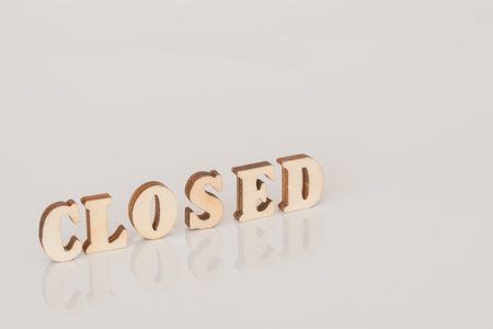 The inscription is Closed with wooden letters on a white background with a reflection. Information...