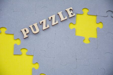 Missing jigsaw puzzle piece on yellow background. Label PUZZLE on top. Home Board game conceptの写真素材