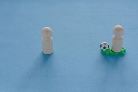People figurines play football. Concept of aggressive attack strategy, team play, protection of your interestsの写真素材