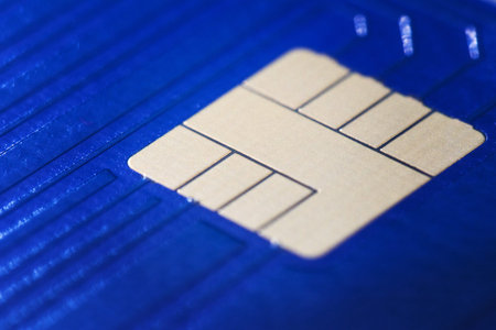 Closeup defocused view of blue plastic credit card EMV micro chip. Selective focus. Financial and...