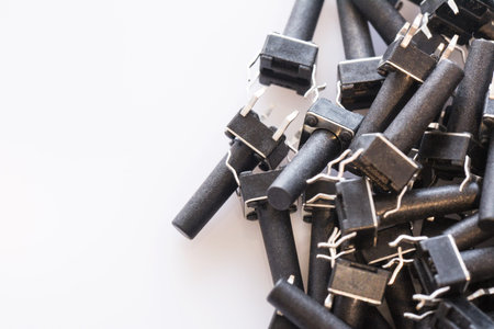 Black microswitch buttons on white background with copyspace. Electronic component textureの写真素材