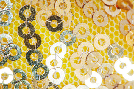 Defocused blurred Gold Colored Sequins fabric background with copyspace for design. Selective focus,...