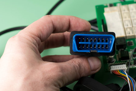 Electrician holds in hands car diagnostic error scanner OBD2 plug.