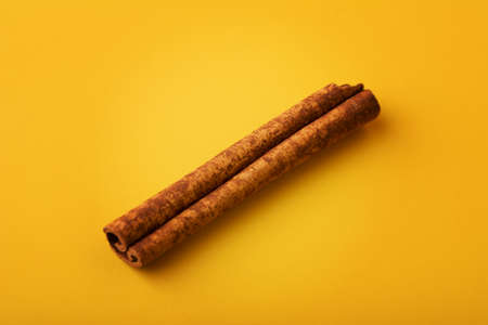 Top view of aromatic dry cinnamon stick isolated on yellow background. Shallow depth of fieldの写真素材