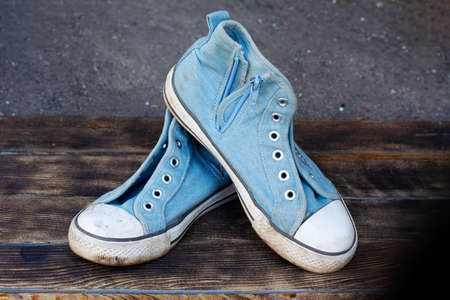 Pair old dirty blue sneakers on wooden backgroundの写真素材