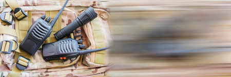 Portable radio set, army radio. Equipment for trekking. Set of traveler or tourist or soldier. Radio for communication, flashlight on background of military backpack camouflage. Panoramic bannerの写真素材