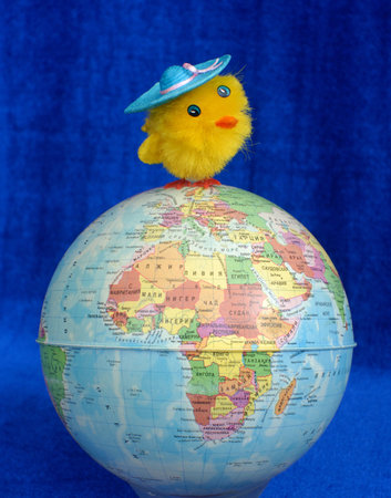 The fluffy toy of a chicken costs at top of the globe.の写真素材