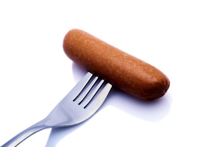 Wiener on a fork in front of a white backgroundの写真素材