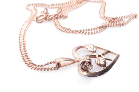 Golden heart  and flower  shaped necklace on white backgroundの写真素材