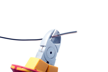 Cutting  cable with nippers isolated on whiteの写真素材