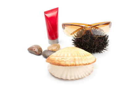 Sun glass on white  background with seashell,stones, sea-urchin and sun block