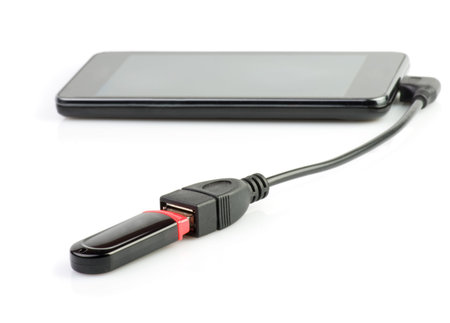 Mobile phone in which a computer flash drive is insertedon a white background