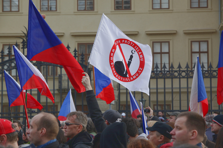 PRAGUE, CZECH REPUBLIC, FEBRUARY 6, 2016: Demonstration against Islam and Immigrants in Prague. A man holding a placard with a warning sign mosque. Hradcanske Square, Central Bohemia, Europe, EUのeditorial素材