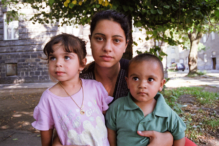 PREROV, CZECH REPUBLIC, JUNE 25, 2011: Charming and poor Gypsy family in the ghetto street Skodova, now defunct ghetto was razed. Photographed on cine-film, photo has a characteristic noise, Europeのeditorial素材