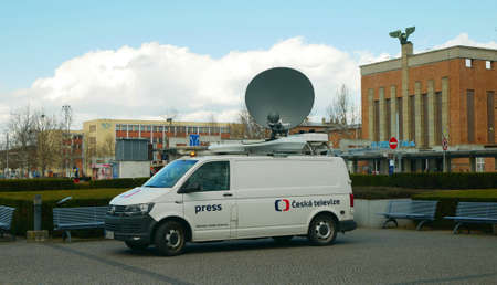 Satellite TV car for live broadcasting to television, modern satellite connection to the transmitter, news antenna warning beacon, technological technology equipment, city street town life, building of the main railway train station Olomouc, Czech Republiのeditorial素材