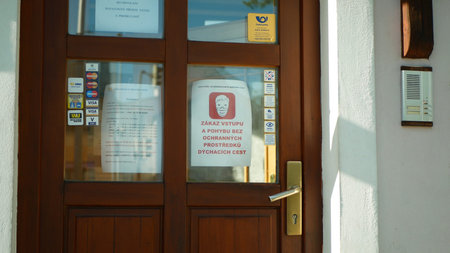 OLOMOUC, CZECH REPUBLIC, APRIL 20, 2020: Entry Czech Post branch door, banner respecting governments...