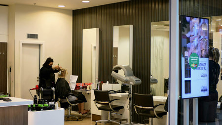 OLOMOUC, CZECH REPUBLIC, JUNE 22, 2020: Coronavirus mask face hairdressing barber cutting female...
