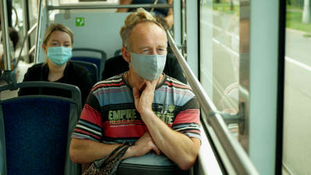 PRAGUE, CZECH REPUBLIC, JUNE 22, 2020: Coronavirus mask face tram streetcar drive crowd people passengers, public transport prevention against risk covid-19 infection flu virus safety outbreakのeditorial素材