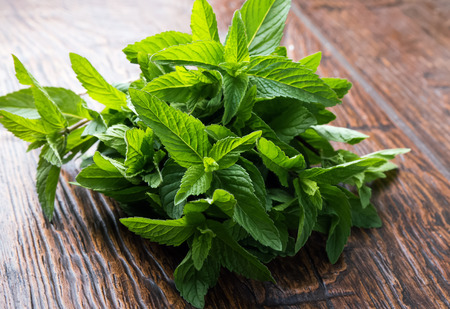 Mint leaves on the wooden table close-upの写真素材