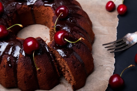 Delicious chocolate cake with glaze and cherries on the black background close upの写真素材