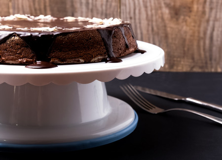 Chocolate cake with chocolate frosting on white standの写真素材