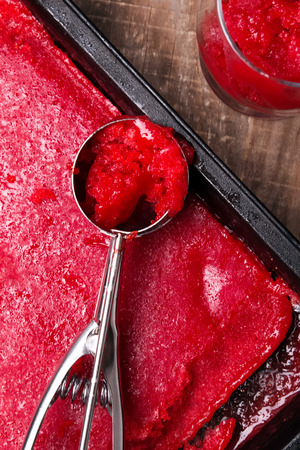 Scoop of strawberry sorbet on the wooden tableの写真素材