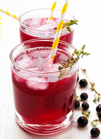 Cold refreshing berry drink with ice and thyme close-upの写真素材