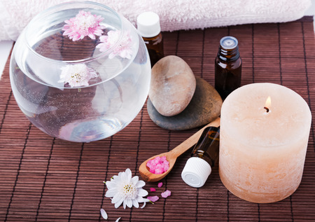 Spa still life. Vase with flowers, candle, sea salt, bottle and stones.の写真素材