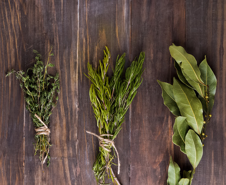 Fresh herbs. Thyme, rosemary and bay leaf brunch on the wooden tableの写真素材