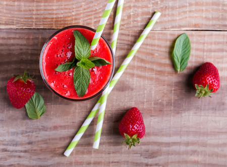 Strawberry smoothie on the wooden table top viewの写真素材