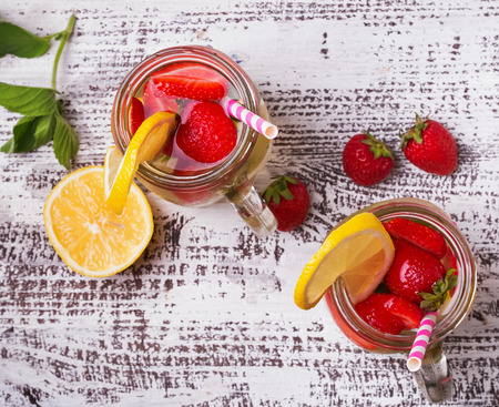 Strawberry and lemon detox water in glass jars, top viewの写真素材