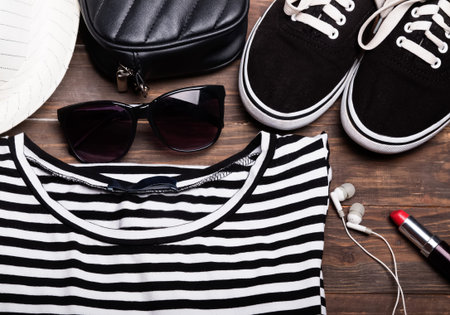 Outfit of modern young girl on the wooden background, top view.