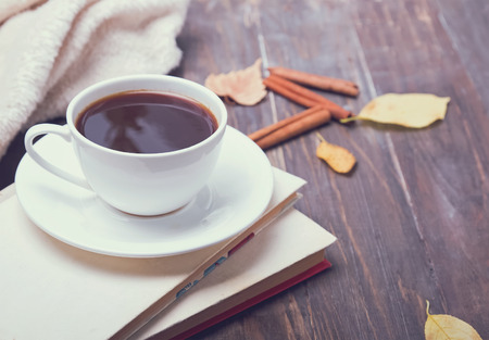 Coffee and books on the woode table. Autumn morning, toned photo.の写真素材