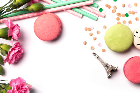Macarons, flowers and souvenir Eiffel tower on the white background, top viewの写真素材