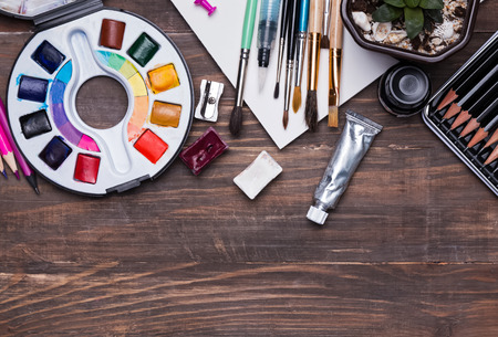 Artist supplies on the wooden background, top viewの写真素材