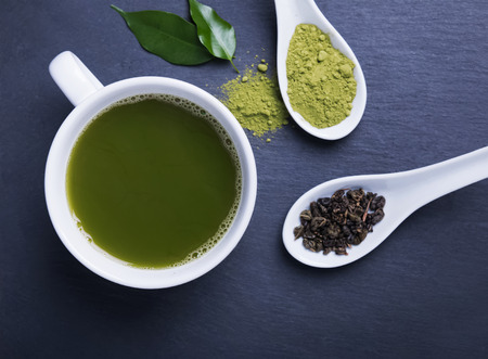 Green tea in a cup on the black background, top viewの写真素材