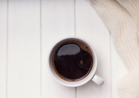 Coffee and sweater on white wooden table, toned photoの写真素材