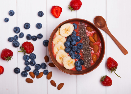 Strawberry smoothie bowl with berries amd chia seeds on white table, top viewの写真素材