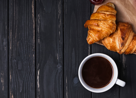 Coffee and croissants on the black wooden background, top viewの写真素材