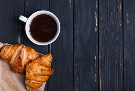 Coffee and croissants on the black table, top viewの写真素材
