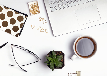 Modern feminine workplace, top view. Laptop and coffee with other small accessoriesの写真素材