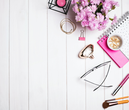 Beautiful small objects and pink flowers on white wooden table, top viewの写真素材