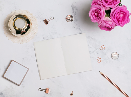 Blank notepad, pink roses and small golden accessories, top viewの写真素材