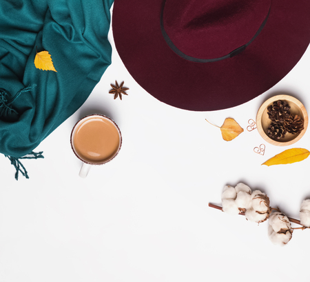 Autumn related accessories on the white. Hat, scarf, cup of coffee and other small objects, top viewの写真素材