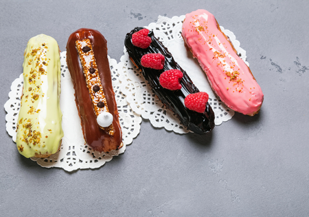 Four delicious glazed eclairs of different flavorsの写真素材