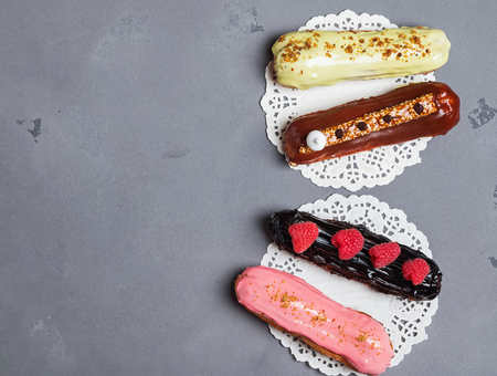 Delicios glazed eclairs with different flavors, top viewの写真素材