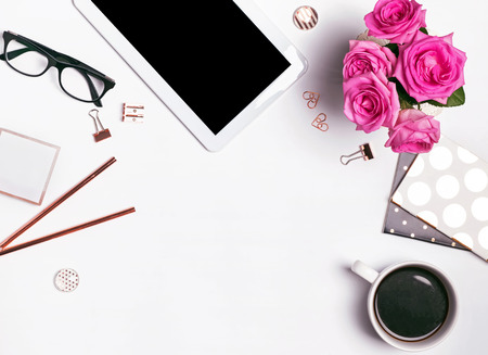 Modern feminine workplace concept. Tablet, coffee, glasses and other objects, top viewの写真素材